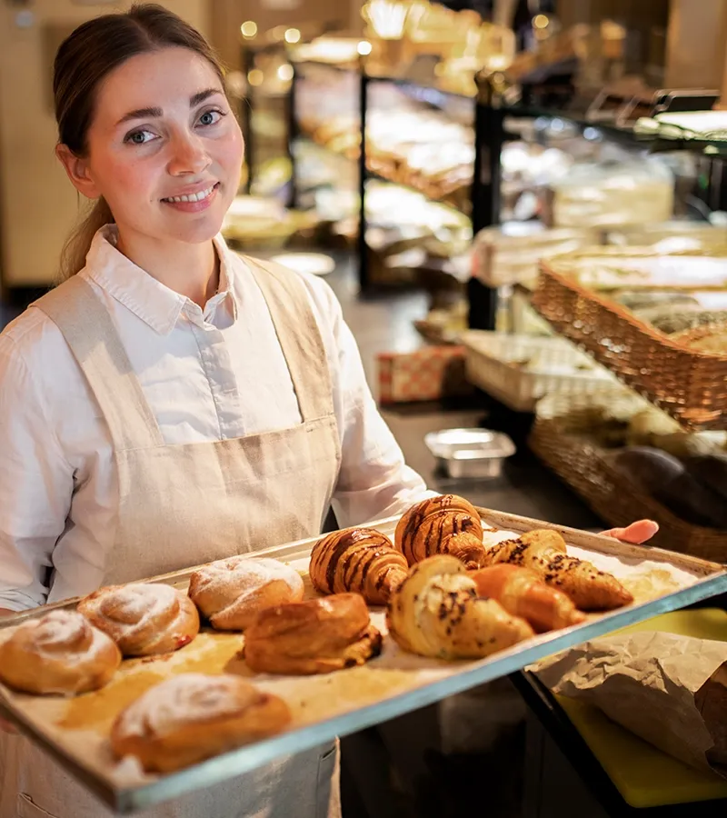 Baker with a plate with freshly prepared croissants